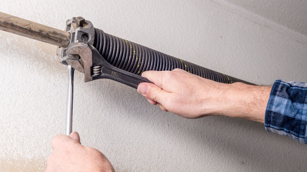 Technician repairing a residential garage door spring system in Lake County, FL